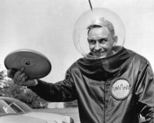 Fred Morisson in a spacesuit selling the Pluto Platter